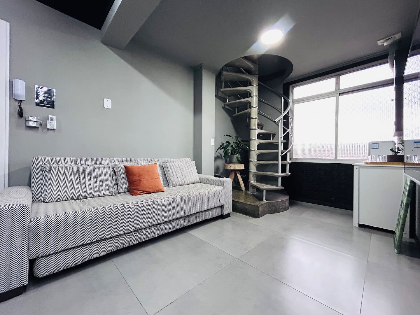 Sala de estar com sofá claro e vista para o terraço