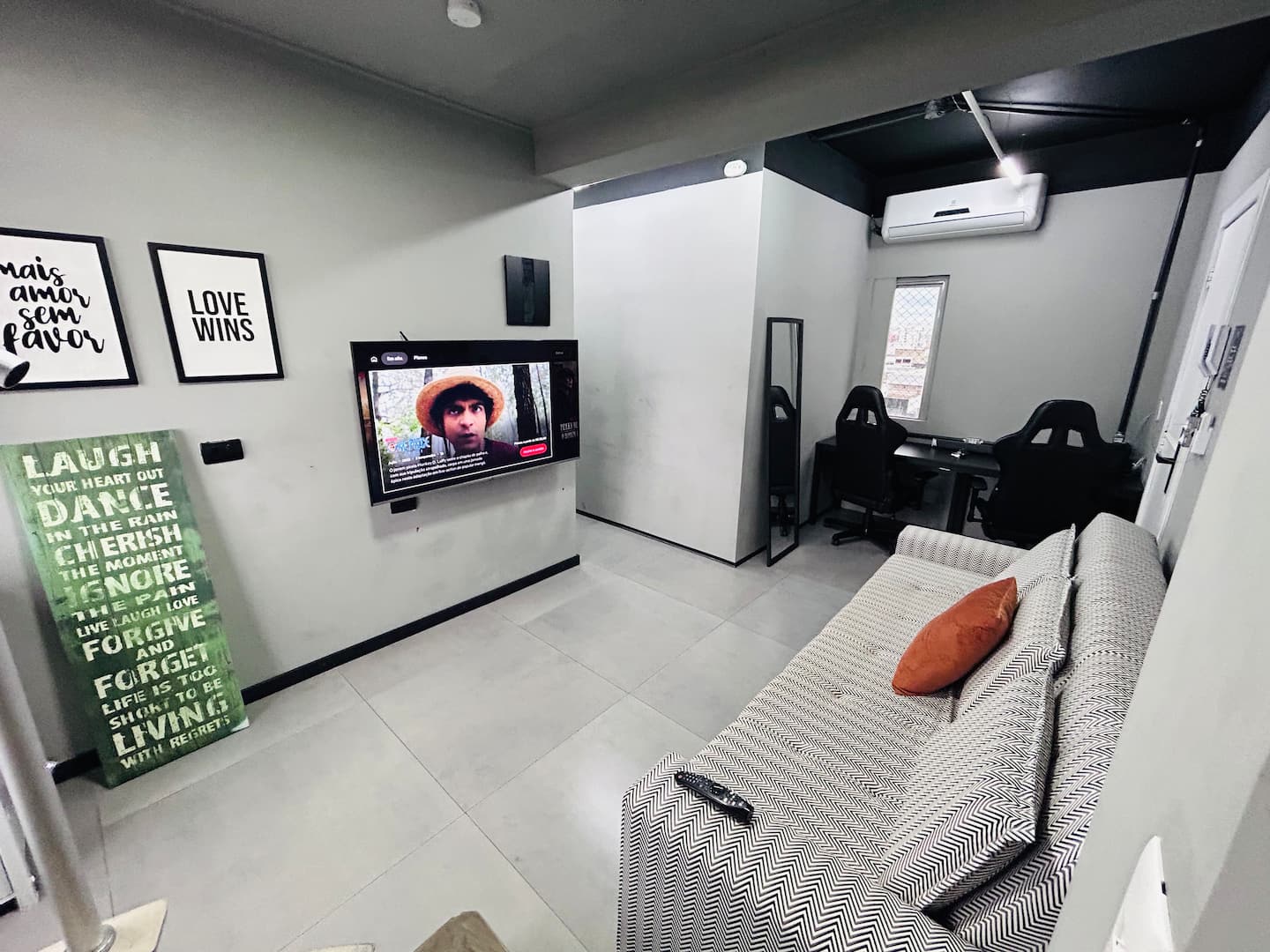 Espaço de convivência com poltrona gamer e TV
