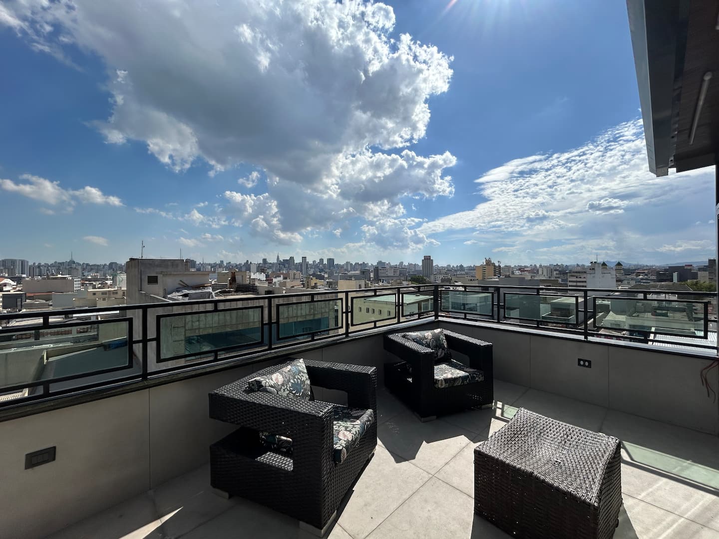 Terraço aberto com poltronas e vista quase 360° da cidade