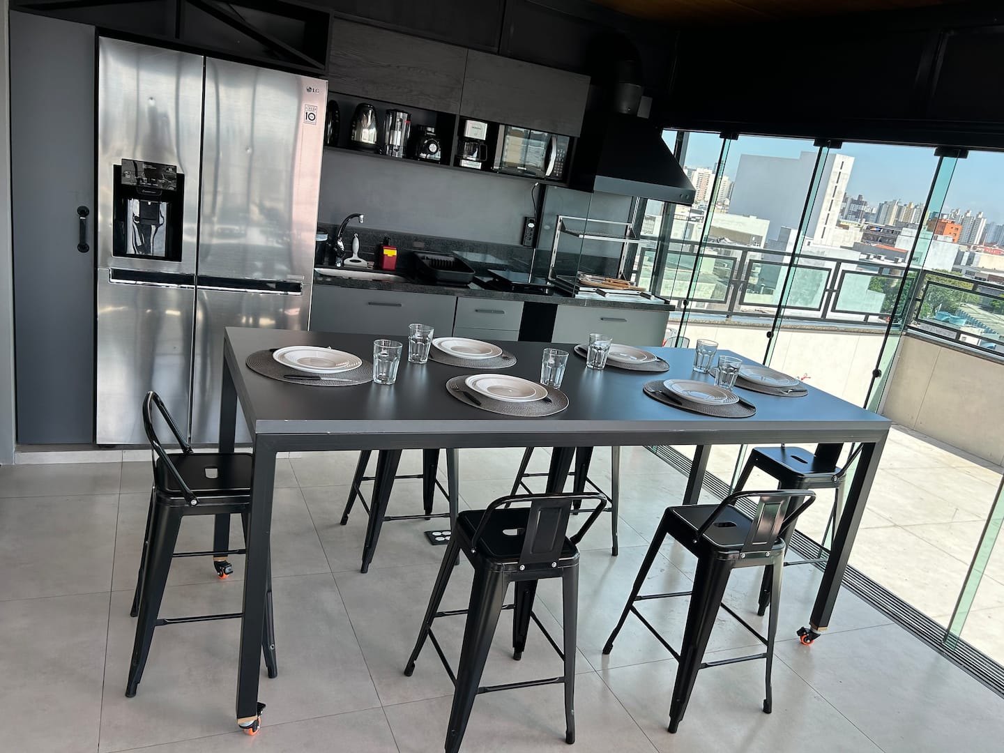 Cozinha industrial com geladeira inox e mesa posta